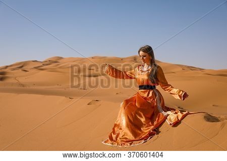 Beautiful Young Girl In Moroccan Dress In Sahara Desert.