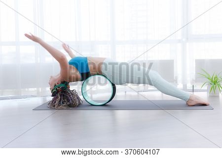 Yoga Indoor. Sports Recreation. Beautiful Young Woman With Dreadlocks In Asana With Yoga Ring In Roo