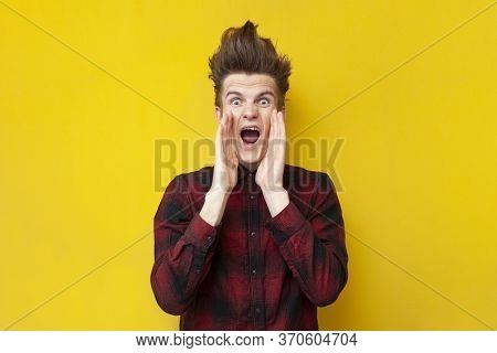 Young Shocked Guy Screaming On A Yellow Isolated Background, Hipster With A Funny Hairstyle Is Panic