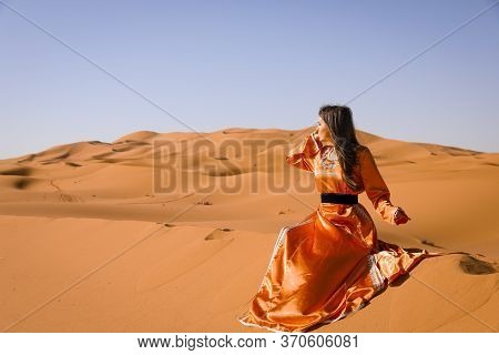 Beautiful Young Girl In Moroccan Dress In Sahara Desert.
