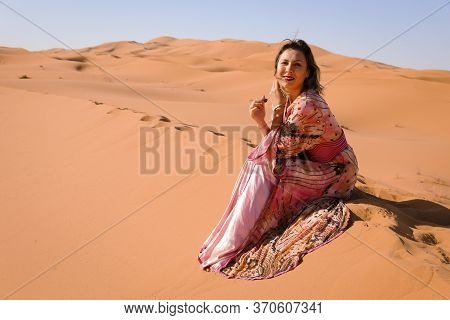 Girl In Moroccan Dress In Sahara Desert.