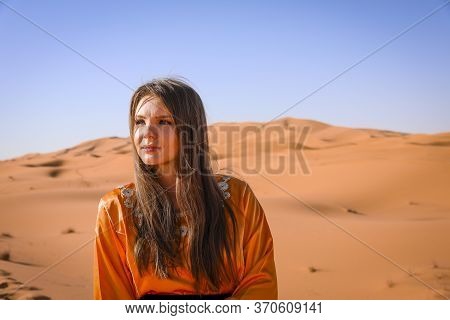 Beautiful Young Girl In Moroccan Dress In Sahara Desert.