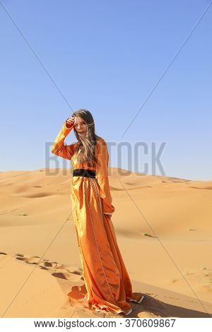 Beautiful Young Girl In Moroccan Dress In Sahara Desert.