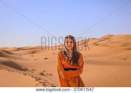 Beautiful Young Girl In Moroccan Dress In Sahara Desert.