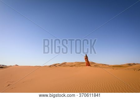 Beautiful Young Girl In Moroccan Dress In Sahara Desert.