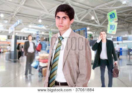 Joven empresario de éxito sonriendo y mirando a la cámara en un moderno aeropuerto