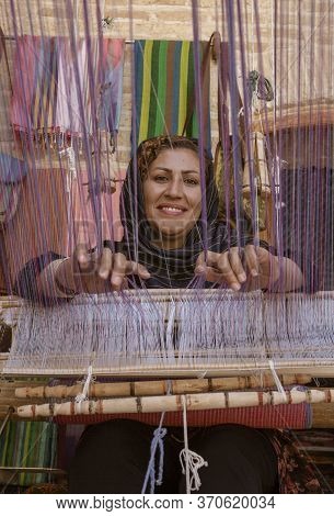 Isfahan, Iran - 2019-04-12 - Woman Weaves Cloth On A Hand Loom.