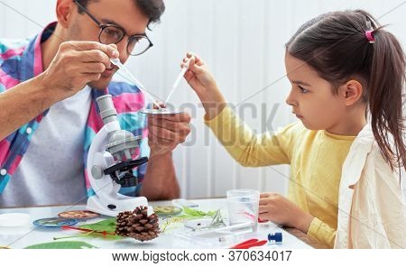 Dad And Little Girl Study Chemistry Lesson With Microscope, Mixing Liquids In The Flasks For Lab Exp