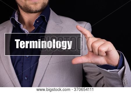 Businessman On A Black Background Holds An Icon With The Text Terminology