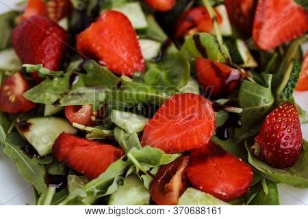 Tasty Summer Salad Made Of Strawberies, Spinach, Ruccola, Cucumber And Balsamic Sauce.