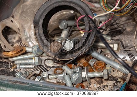 Rusty Bolts With Nuts, Rubber Tubes And Wires Under The Hood Of An Old Broken Car
