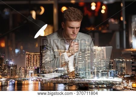 Double Exposure Of Young Man Working In Office And Night Cityscape. Financial Analytics