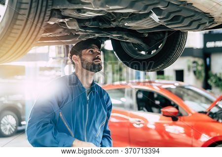 Auto Check Up And Car Service Shop Concept. Mechanic Writing Job Checklist To Clipboard To Estimate 