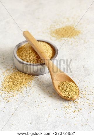 Bowl Of Raw Amaranth Grain With A Spoon Close Up On A White Table