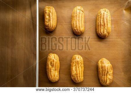 Close Up Choux Baked Home Made  Fresh Crispy Eclairs And Profiteroles. Making Desserts And Sweets On