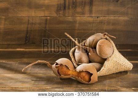 Tamarind Tropical Fruit - Tamarindus Indica. Wood Background