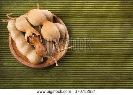 Tamarind Tropical Fruit - Tamarindus Indica. Wood Background