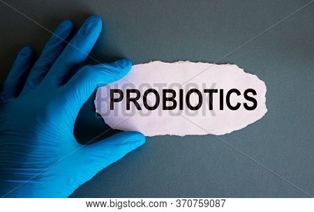 Hand In Blue Glove With White Small Paper. Concept Word Probiotics.