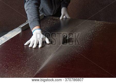 The Master Saws A Brown Building Shield. Master Saws Plywood On A Circular Saw. Cutting Moisture-pro