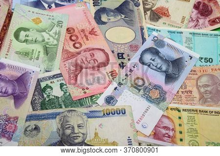Mix Of Chinese, Indian, Japanese, Lao And Thai Colorful Banknotes Close Up.