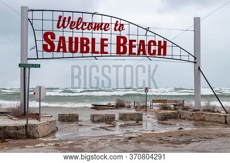 Welcome To Sauble Beach Sign At The Entrance On A Very Rough Day With High Water And Waves