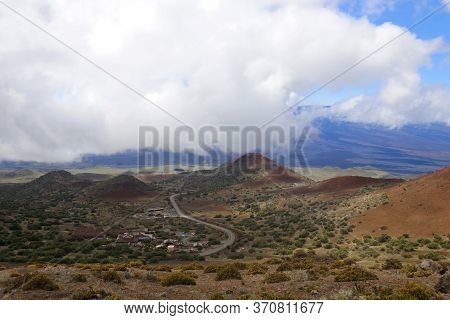 Scenic Mauna Kea Landscape With Paved Road To Summit Between Old Craters And View On Mauna Loa In Cl