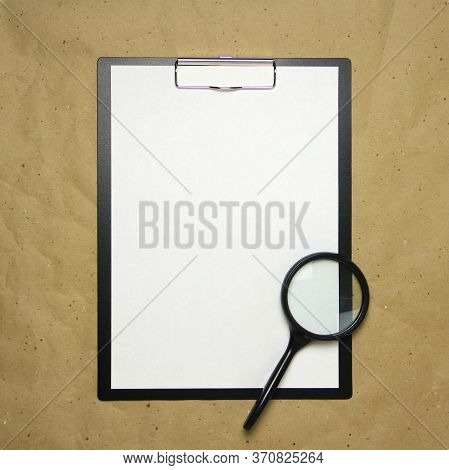 A Tablet With A White Sheet Of A4 Format With Magnifier On A Beige Craft Paper. Concept Of Analysis,