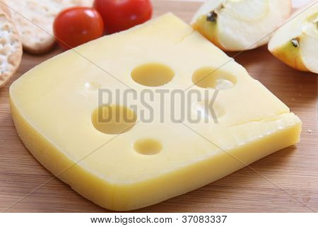 Ein Keil der Jarlsberg dänische Käse mit Cracker und Cherry-Tomaten auf einer Käseplatte