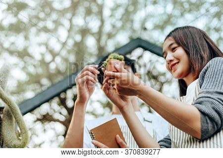 Women Hold Cactus And A Man Hands Point . Love Couple Enjoy Hobby With Darden Cactus.