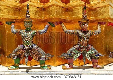 Two Giant Ramayana Statues Liftting Golden Pagoda At Wat Pra Kaew, Grand Palace, Bangkok, Thailand. 