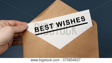 Cropped View Of Man Holding Craft Envelope With Text Best Wishes On Blue Background