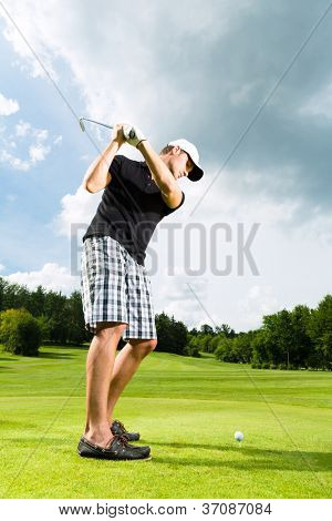 Young golf player on course doing golf swing, he presumably does exercise