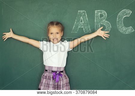 Portrait Of Caucasian Happy Child Girl With. School Chalkboard Or Blackboard Background. Education C