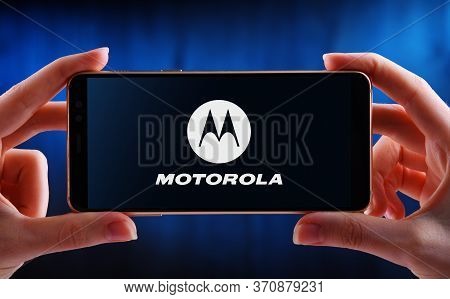 Poznan, Pol - May 21, 2020: Hands Holding Smartphone Displaying Logo Of Motorola, Inc.,  An American