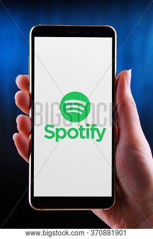 Hands Holding Smartphone Displaying Logo Of Spotify
