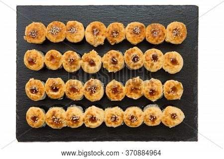 Set Of Fried Sushi Rolls With Fish And Rice On Black Stone Slate