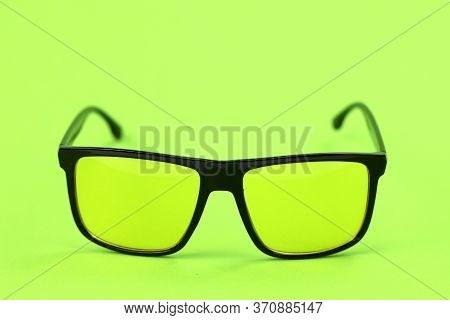 Designer Hipster Sunglasses In Black Plastic Rim With Colored Yellow Lenses Isolated On Yellow Backg