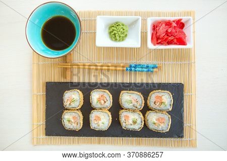 Sushi Rolls On Black Slate Surface. Japanese Food. Hot Fried Sushi Roll