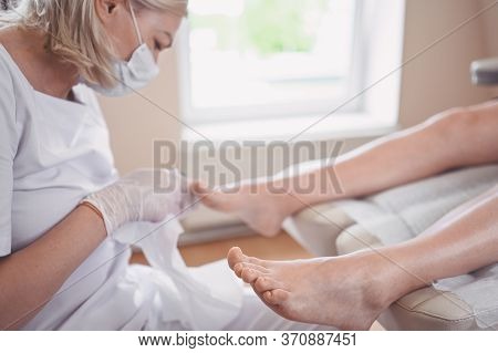 Pedicurist Doing Professional Medical Pedicure Procedure In Beauty Salon With Special Eguipment. Foo