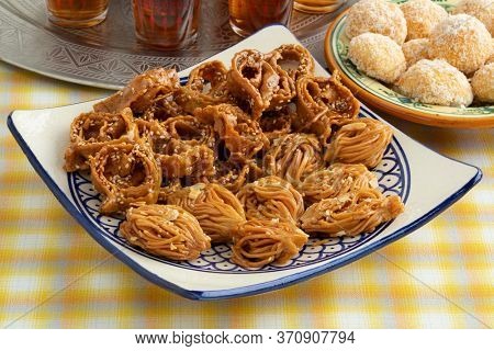 Dish with Moroccan festive homemade chebakia, coconut cookies close up and tea