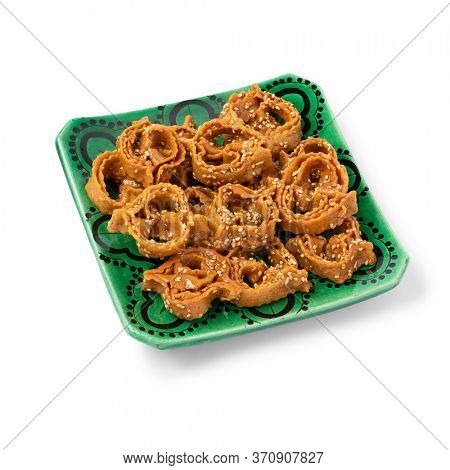 Dish with Moroccan festive homemade chebakia cookies isolated on white background