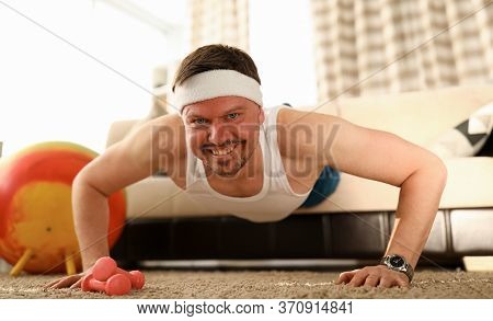 Man At Home Doing Pushups On Carpet And Sofa. Exercises For Problem Areas And Training Other Muscle 