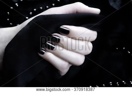 Female Hand With Black Manicure On A Black Background