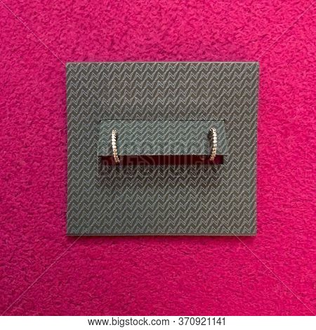 Closeup Of Small, Silver Earrings Displayed In It's Original Packaging, Shot Flaylay Style On A Vivi