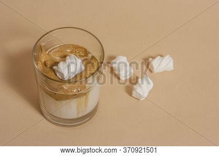 Dalgon Coffee In A Transparent Glass With Milk On A Pastel Background With Marshmallows.