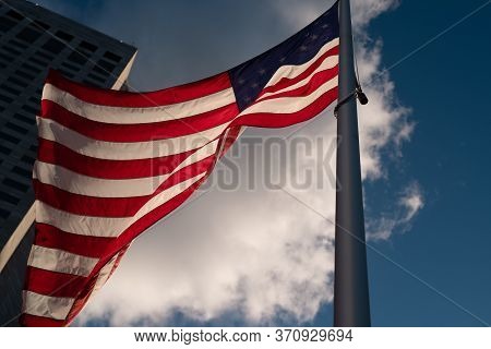 Independence Day. Happy 4th Of July Usa. Waving American National Flag And Skyscrapers On The Backgr