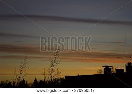 Silhouette Of Building With Yellowish Orange Twilight Sky In The Background