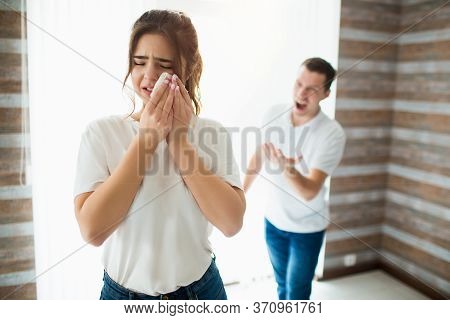 Young Woman And Man In Room During Quarantine. Guy Scream At His Wife. She Crying And Hold White Tis