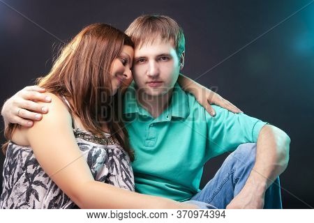 Family And Relationships Concepts. Portrait Of Pregnant Woman Together With Her Husband Sitting Toge