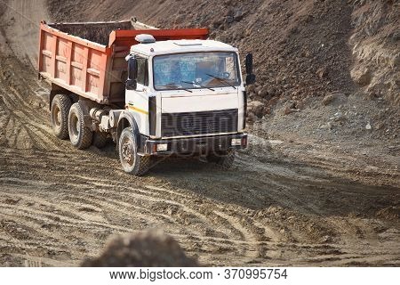 Heavy Multi-ton Mining Truck Exporting Minerals From Open-pit Mine. Concept Of Shipping And Protecti